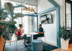 a woman and a man talking in an office